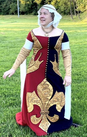 Sancha in a heraldic gown showing her device.